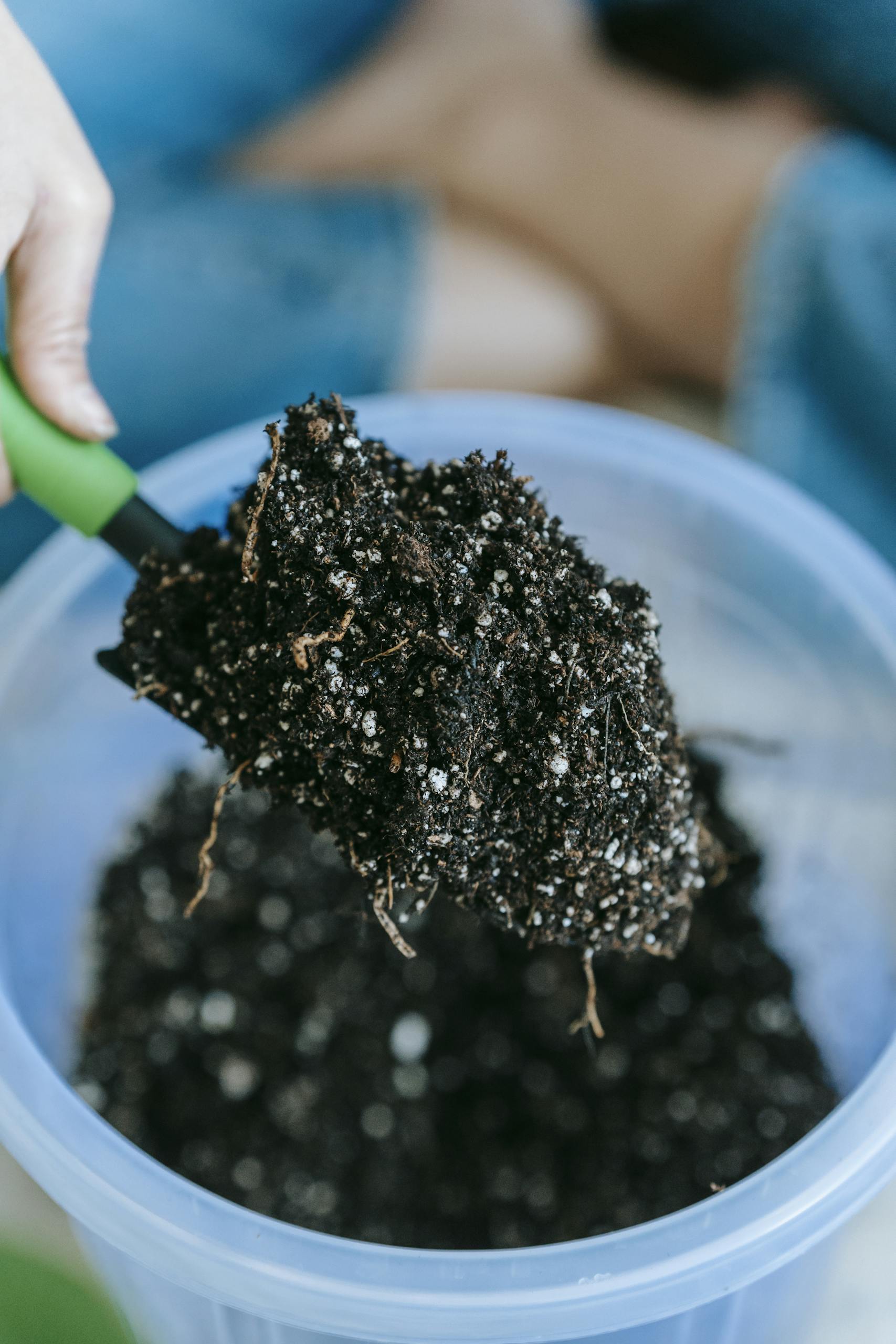 Close-up of soil being scooped with a trowel for gardening purposes.